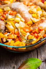 Autumn foodie, roasted chicken with pumpkin, carrots, potatoes and spices in glass pan. Selective focus. Shallow depth of fied.