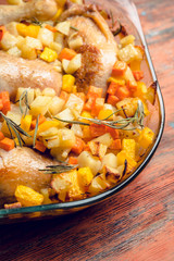 Autumn foodie, roasted chicken with pumpkin, carrots, potatoes and spices in glass pan. Selective focus. Shallow depth of fied.