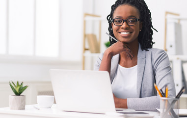 Confident African American Businesswoman Smiling At Camera At Workplace - obrazy, fototapety, plakaty