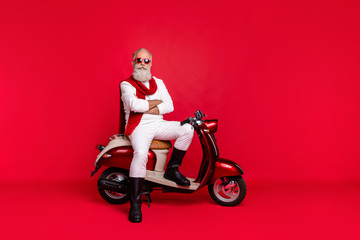 Fototapeta na wymiar Full length body size view of his he nice attractive well-groomed stylish trendy content virile gray-haired man sitting on bike folded arms isolated over bright vivid shine red background