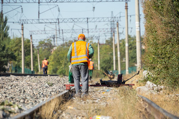 workers check for broken old reinforced concrete sleepers to replace them with new ones on the railway using equipment