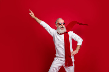 Fototapeta na wymiar Cool santa character aged man directing finger on advert banner wear sun specs knitted clothes isolated red background