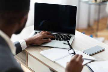 Black businessman working on laptop on his workplace