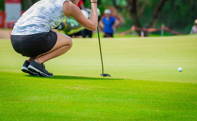 Professional woman golfer checking fairway and teeing golf in golf tournament competition at golf course for winner.  