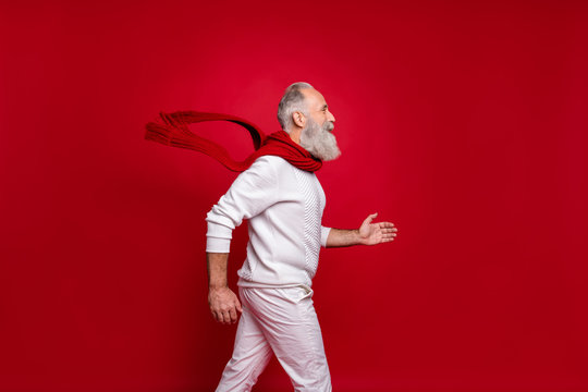 Hipster Senior Man Plays Rushing Santa At Corporate Party Wearing Fashion Knitted Clothes Isolated Red Background