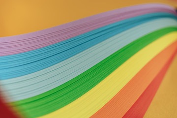Close up beautiful rainbow color ribbon on orange background.