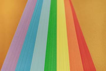 Close up beautiful rainbow color ribbon on orange background.