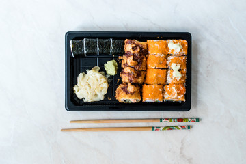 Sushi Set in Plastic Container Box / Package. California Roll, New York Roll, Boom Roll, Ginger, Wasabi and Soy Sauce.