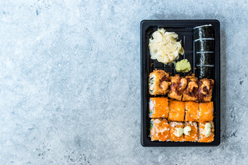 Sushi Set in Plastic Container Box / Package. California Roll, New York Roll, Boom Roll, Ginger, Wasabi and Soy Sauce.