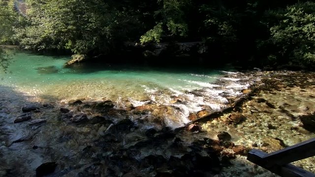 Slow motion right pan Sava Bohinjka river flows in Bohinj lake