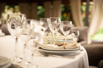 Table setting set with flowers. Modern and elegant decoration of table set for celebration with white utensil.