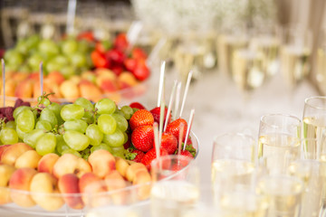 Glasses of wine and champagne. Fruit on a banquet table. Banquet service.