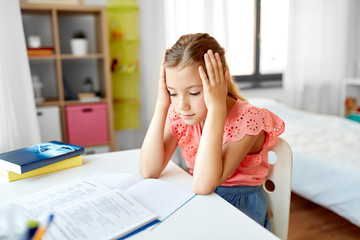 children, education and learning concept - sad student girl with notebook at home