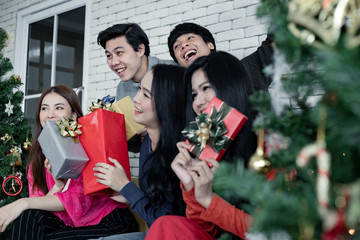 Group young Asian with gifts at home in celebrating Christmas festival.