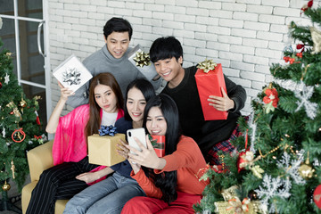 Selfie of group young Asian with gifts at home in celebrating Christmas festival.
