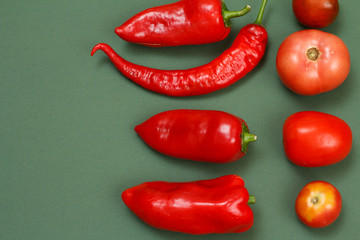 Top view of fresh vegetables and fruits on green background.