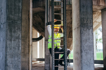 worker climbing on ladders on construction site
