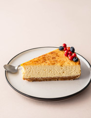Slice of cheesecake with berries on a plate. Copy space.