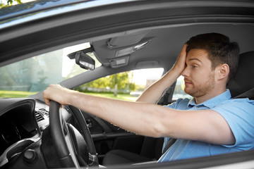 transport, vehicle and driving concept - tired sleepy man or car driver rubbing eyes