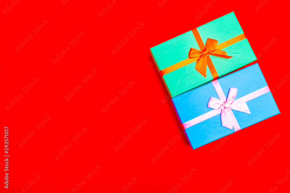 Aufkleber colored boxes with ribbons on a red background. view from above.