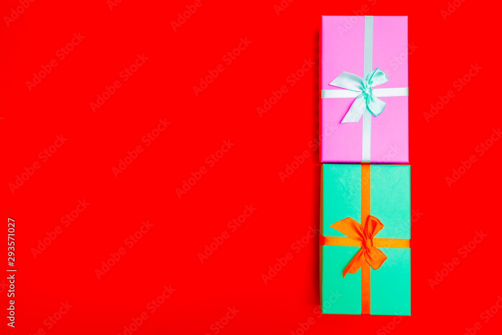 Poster colored boxes with ribbons on a red background. view from above.