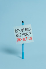 Text sign showing Dream Big Set Goals Take Action. Business photo showcasing Motivation to follow your dreams Inspiration Ballpoint blank colored sticky note peaceful cool pastel fashion background