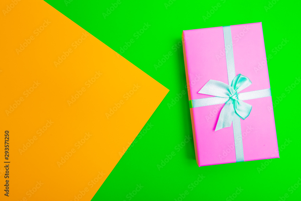 Poster gift box with ribbon on a colorful background. view from above.