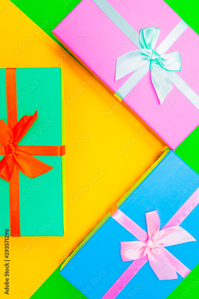 Aufkleber colored boxes with ribbons on a colorful background. view from above.