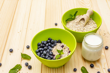 Oatmeal porridge with fresh blueberry, mint leaves and yogurt