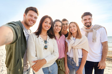 friendship, leisure and people concept - group of happy friends taking selfie on beach in summer