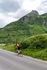 Cyclist rides on tourist mountain pass Silvretta High Alpine Road, Austria