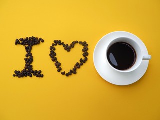 The white coffee cups and the coffee beans are arranged as 