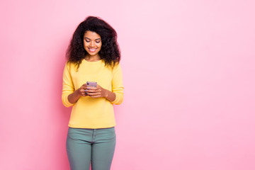 Portrait of cheerful positive interested black girl hipster use her phone comment posts enjoy blogs...