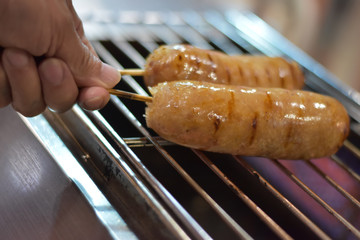 People grilling northeast sausages