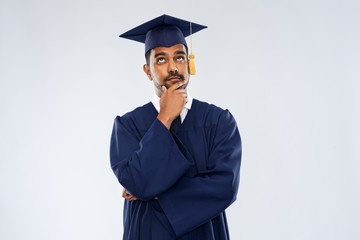 education, graduation and people concept - thinking indian male graduate student in mortar board...