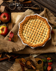 overhead shot of homemade thanksgiving warm baked apple lattice pie crust on sackcloth on rustic...