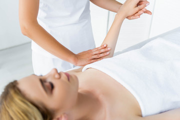 Fototapeta premium cropped view of masseur doing hand massage to attractive woman