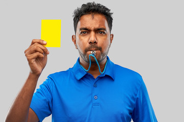 sport, caution, game and football concept - indian referee whistling and showing yellow card