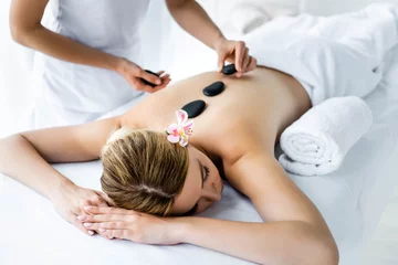 Rolgordijnen cropped view of masseur doing hot stone massage to woman in spa © LIGHTFIELD STUDIOS