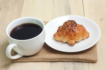 Croissant and coffee  isolated on wood table