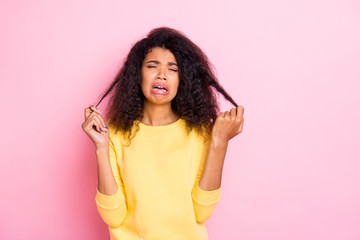 Portrait of negative unhappy african girl look at her damaged dry hair cry feel misery about new salon treatment anti dander dandruff therapy wear yellow pullover isolated over pastel color background