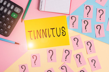 Conceptual hand writing showing Tinnitus. Concept meaning A ringing or music and similar sensation of sound in ears Mathematics stuff and writing equipment on pastel background