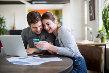 Young adult couple celebrating getting a mortgage together