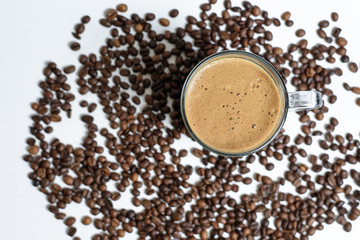 a Cup of fresh coffee with foam stands on coffee beans on a white background . space for text. background image