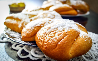 Tea rolls in powdered sugar in a glass plate on the tablecloth