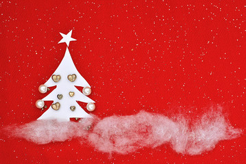 Christmas picture made from manually created handmade elements Christmas tree cut from paper and decorated with beads and snow and xmas tree made from thread and decorated red background