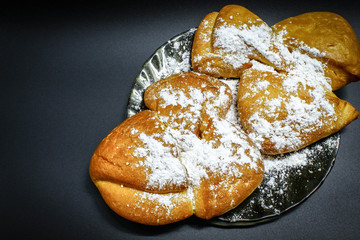 Two fresh and delicious rolls with Apple jam and powdered sugar lie on a glass plate