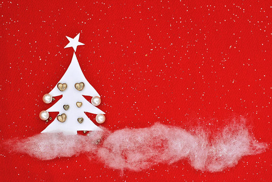 Christmas picture made from manually created handmade elements Christmas tree cut from paper and decorated with beads and snow and xmas tree made from thread and decorated red background