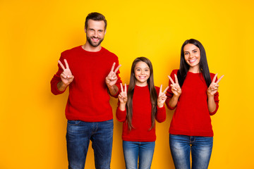 Photo of cheerful cute nice charming family showing you v-sign greeting you wearing jeans denim smiling toothily happily isolated over vivid color yellow background