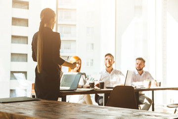 A team of young businessmen working and communicating together in an office. Corporate businessteam and manager in a meeting. desktop against the background of the pan window, free space for text